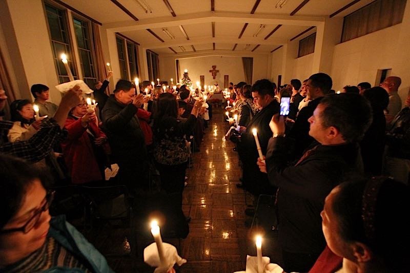 Participants holding candles during evening prayer at a FIRES gathering