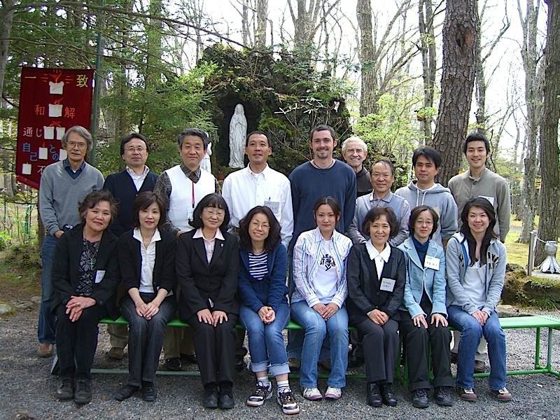 Participants of a FIRES Marriage Encounter at Lake Yamanaka, Japan, standing outdoors among trees