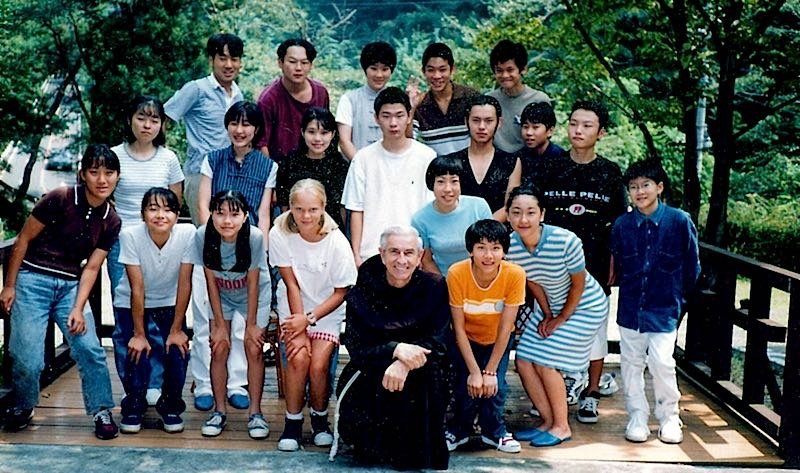 Young people and families at a FIRES Sons and Daughters Encounter in Ota, Gunma, gathered on a balcony with a priest